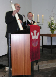 Pfarrer Spieß überreicht zum 25jährigen Jubiläum der Kirche eine Kerze